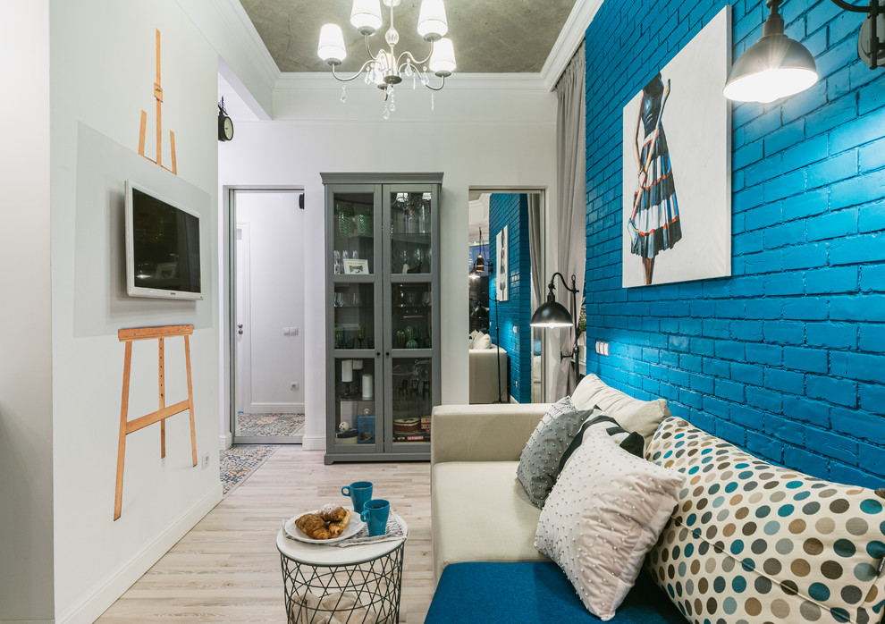 Стильный дизайн: маленькая открытая гостиная комната в стиле фьюжн с полом из ламината, телевизором на стене и серым полом для на участке и в саду - последний тренд