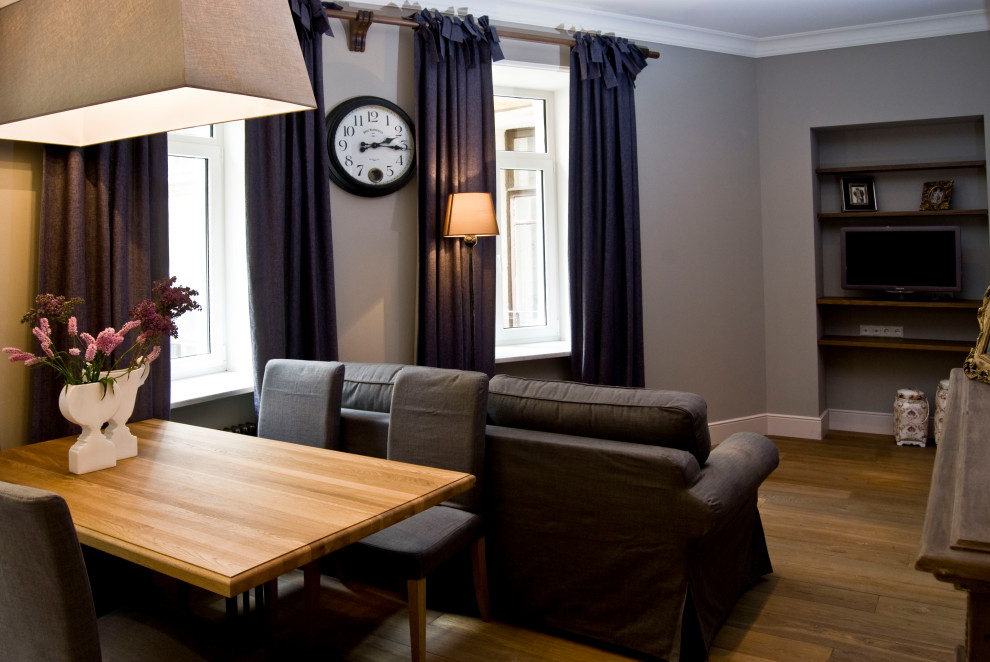 На фото: маленькая изолированная, объединенная гостиная комната в классическом стиле с серыми стенами, деревянным полом и телевизором на стене для на участке и в саду с