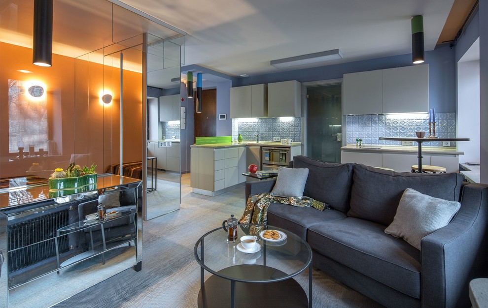 Стильный дизайн: парадная, открытая, объединенная гостиная комната в современном стиле с синими стенами, полом из винила и серым полом - последний тренд