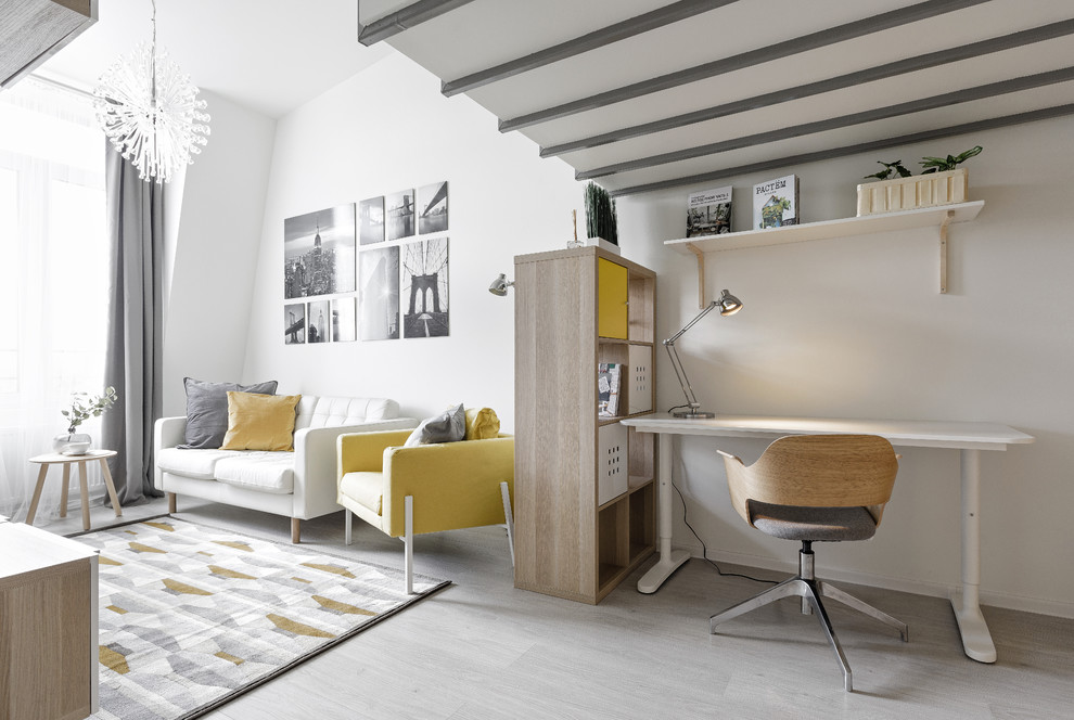 На фото: изолированная гостиная комната среднего размера в скандинавском стиле с белыми стенами, полом из ламината, отдельно стоящим телевизором и серым полом