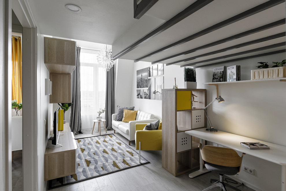 Foto di un soggiorno scandinavo chiuso e di medie dimensioni con pareti bianche, TV autoportante, pavimento grigio e pavimento in laminato