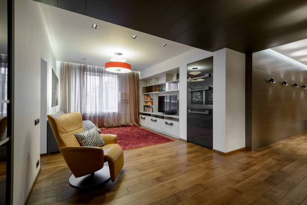 Esempio di un soggiorno contemporaneo di medie dimensioni e aperto con sala giochi, pareti beige, pavimento in legno massello medio e TV a parete