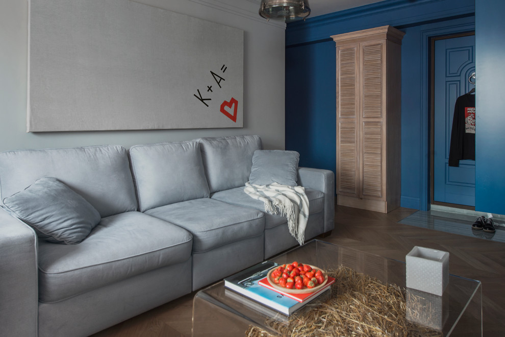 На фото: гостиная комната в современном стиле с серыми стенами и паркетным полом среднего тона с