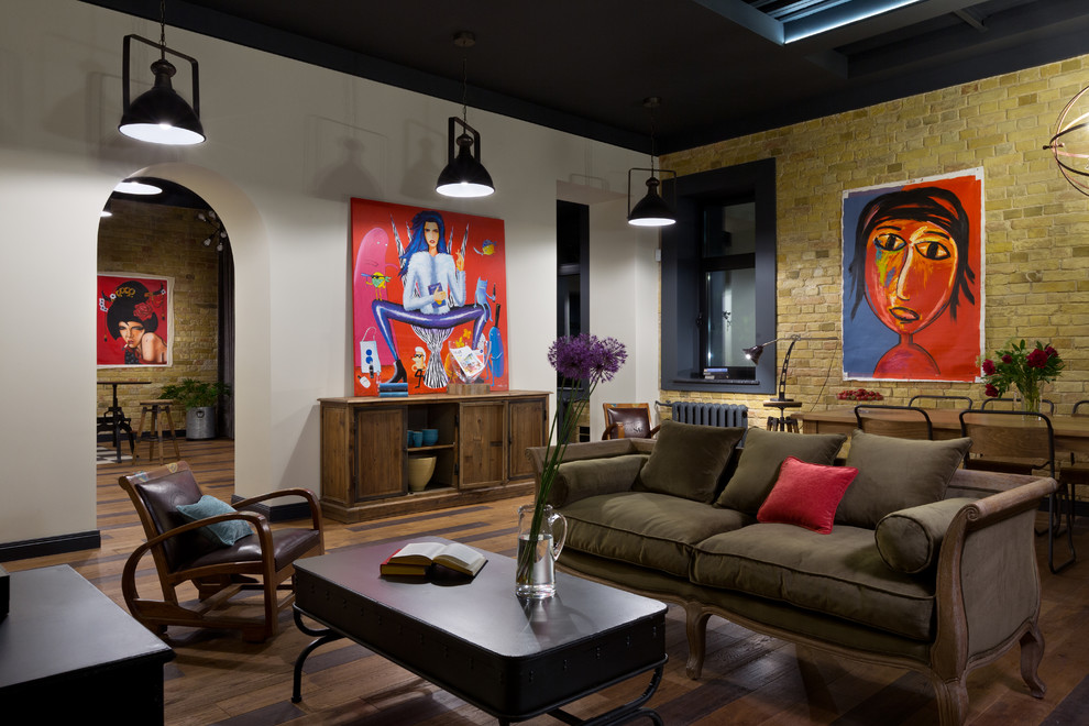 Esempio di un soggiorno industriale di medie dimensioni e stile loft con libreria, pavimento in legno massello medio e TV a parete