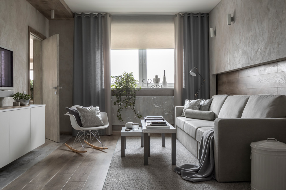 Ispirazione per un soggiorno design aperto con pareti beige, pavimento in legno massello medio, TV a parete e pavimento marrone