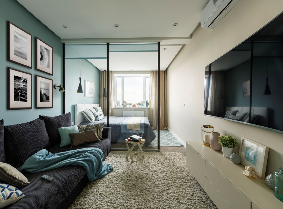 Bild på ett litet funkis separat vardagsrum, med blå väggar, laminatgolv, en väggmonterad TV och beiget golv