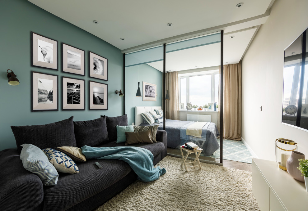 Источник вдохновения для домашнего уюта: маленькая изолированная гостиная комната в современном стиле с синими стенами, полом из ламината, телевизором на стене и бежевым полом для на участке и в саду