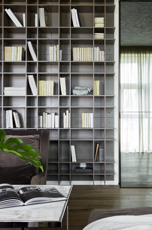 Esempio di un grande soggiorno design con libreria, pareti grigie, parquet scuro, pavimento marrone e pareti in legno