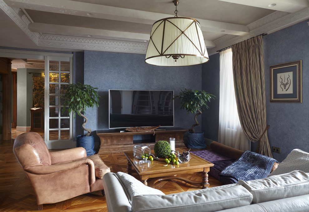 Diseño de salón cerrado clásico con paredes azules, suelo de madera en tonos medios y televisor independiente
