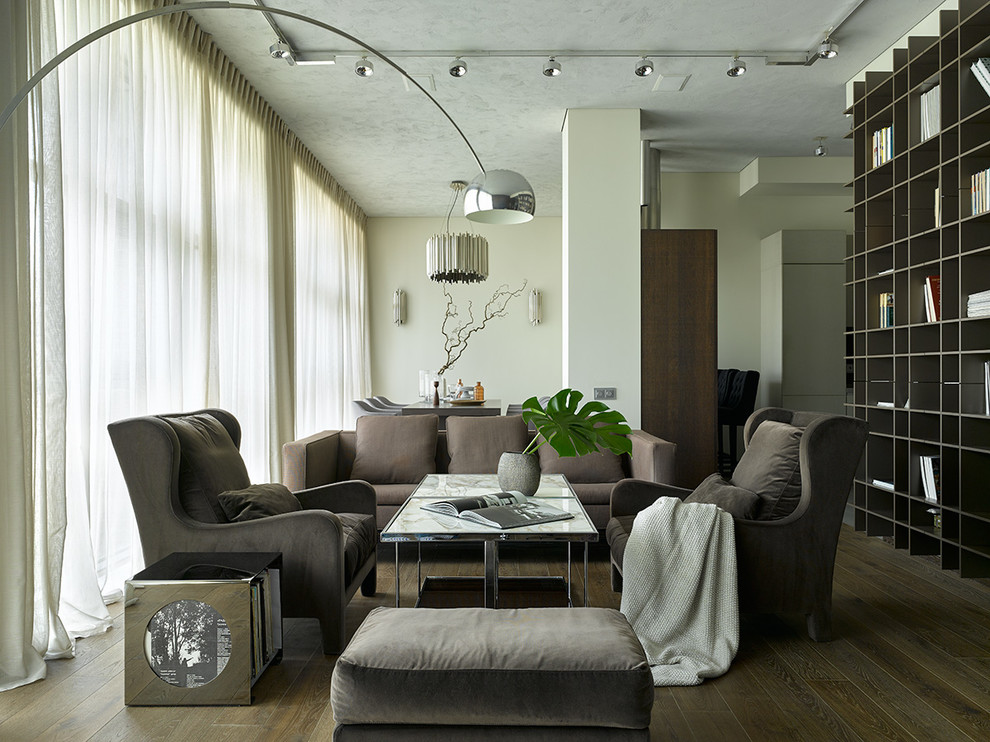 Foto di un soggiorno contemporaneo aperto con libreria, pareti bianche, parquet scuro e pavimento marrone