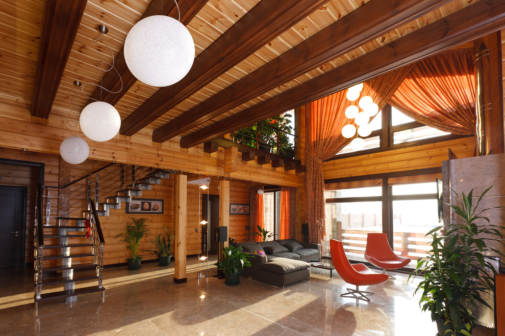 Источник вдохновения для домашнего уюта: большая открытая гостиная комната в современном стиле с коричневыми стенами, мраморным полом, стандартным камином, фасадом камина из камня и телевизором на стене