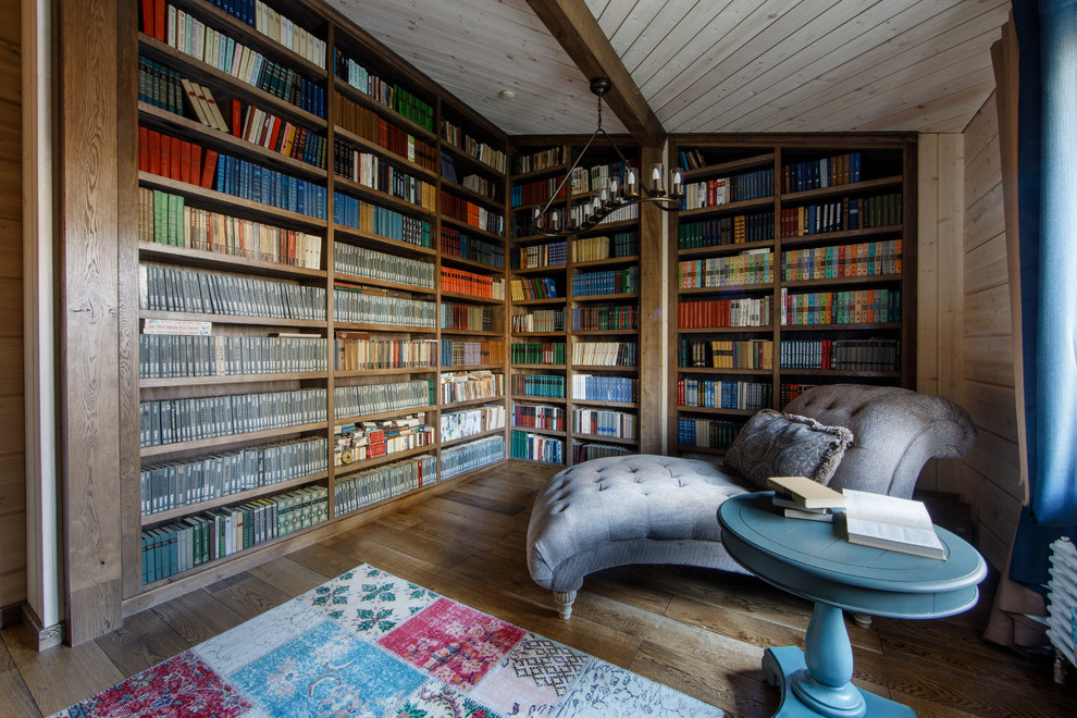 Ejemplo de sala de estar con biblioteca ecléctica con paredes marrones y suelo de madera en tonos medios