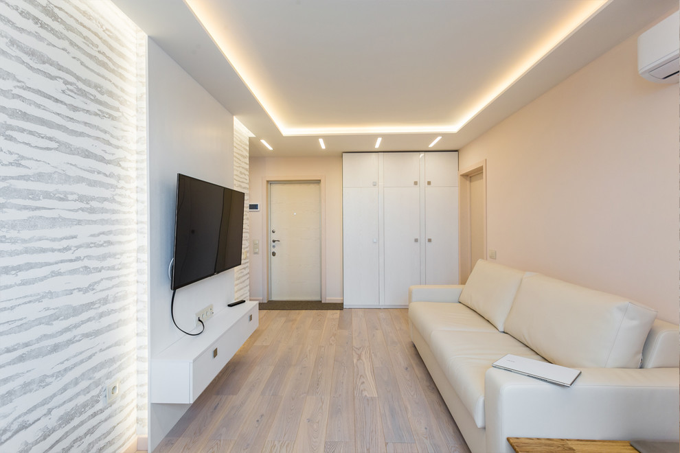 Idée de décoration pour un petit salon design fermé avec une salle de réception, un mur blanc, parquet clair, un téléviseur fixé au mur et un sol blanc.