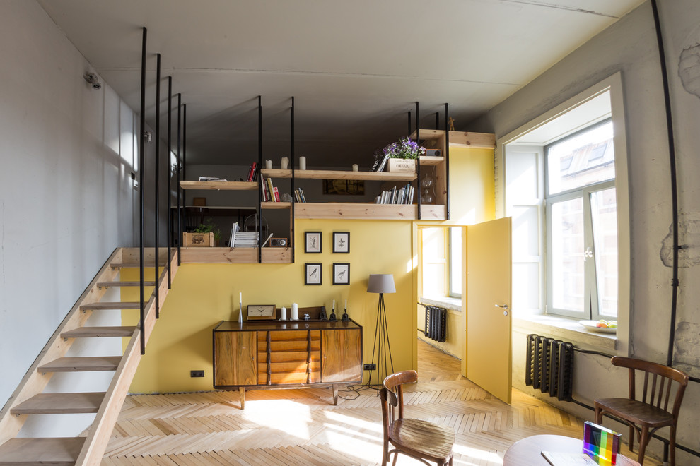 На фото: маленькая двухуровневая гостиная комната в стиле лофт с желтыми стенами и паркетным полом среднего тона для на участке и в саду с