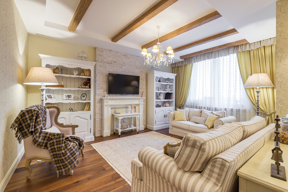 Immagine di un soggiorno classico con pavimento in legno massello medio, camino classico, TV a parete e pareti gialle