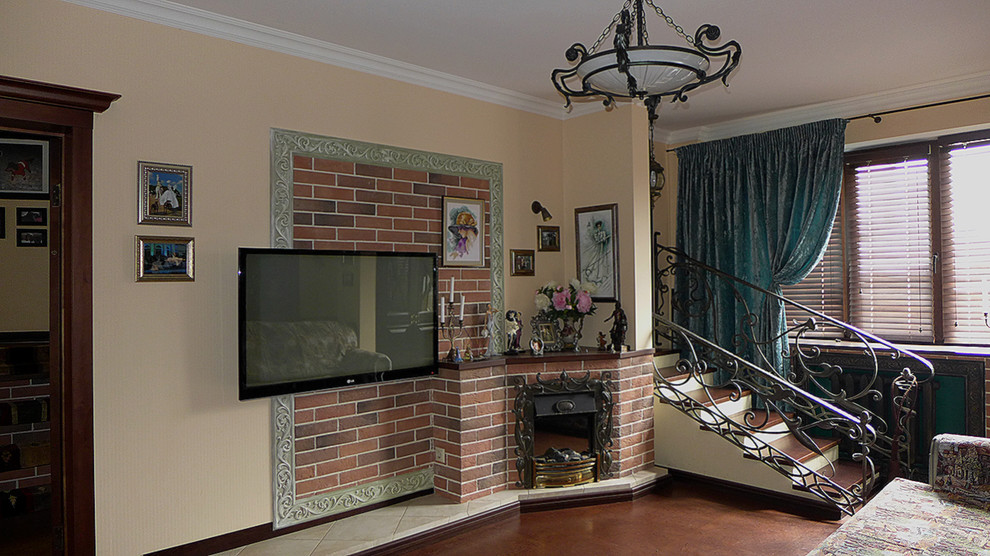 Источник вдохновения для домашнего уюта: открытая гостиная комната среднего размера в стиле фьюжн с бежевыми стенами, пробковым полом, угловым камином, фасадом камина из кирпича и телевизором на стене