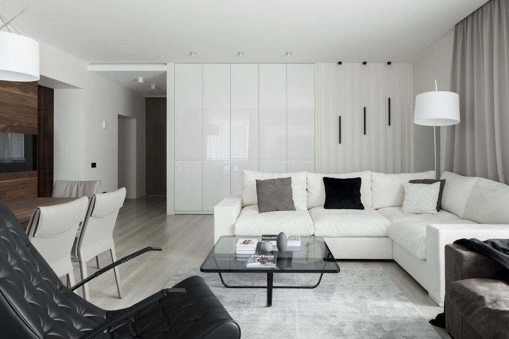 Идея дизайна: большая открытая гостиная комната в современном стиле с белыми стенами, паркетным полом среднего тона, горизонтальным камином, фасадом камина из дерева, телевизором на стене и бежевым полом