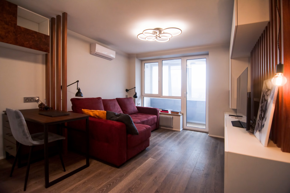 Foto di un piccolo soggiorno nordico chiuso con sala formale, pareti grigie, pavimento in legno massello medio, TV autoportante, pavimento marrone e pareti in legno