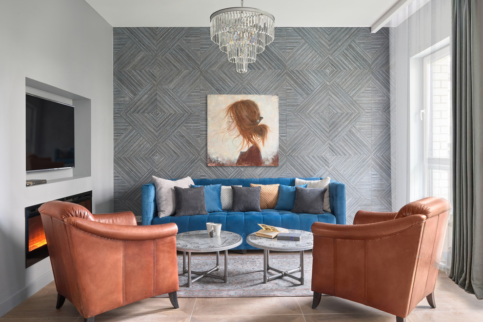 На фото: открытая гостиная комната в современном стиле с серыми стенами, горизонтальным камином, телевизором на стене, коричневым полом и синим диваном с