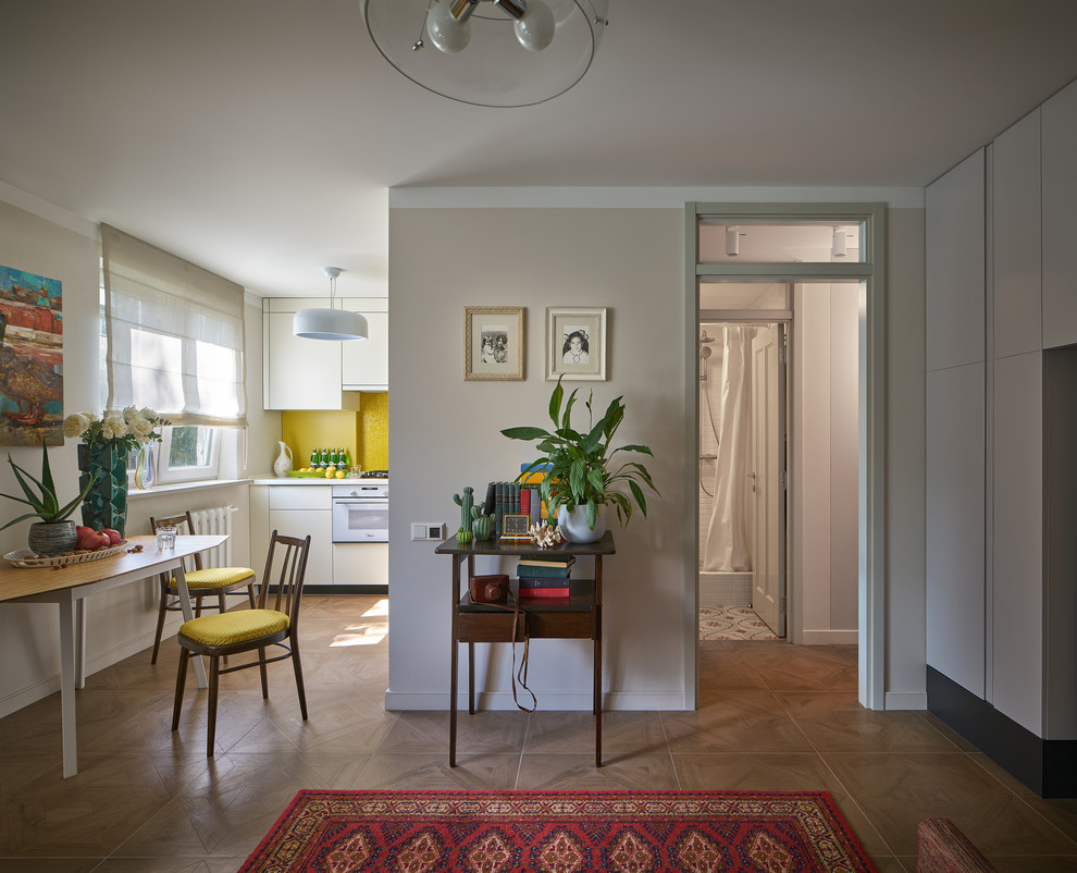 На фото: маленькая открытая, объединенная гостиная комната в стиле фьюжн с серыми стенами, полом из керамогранита и коричневым полом для на участке и в саду