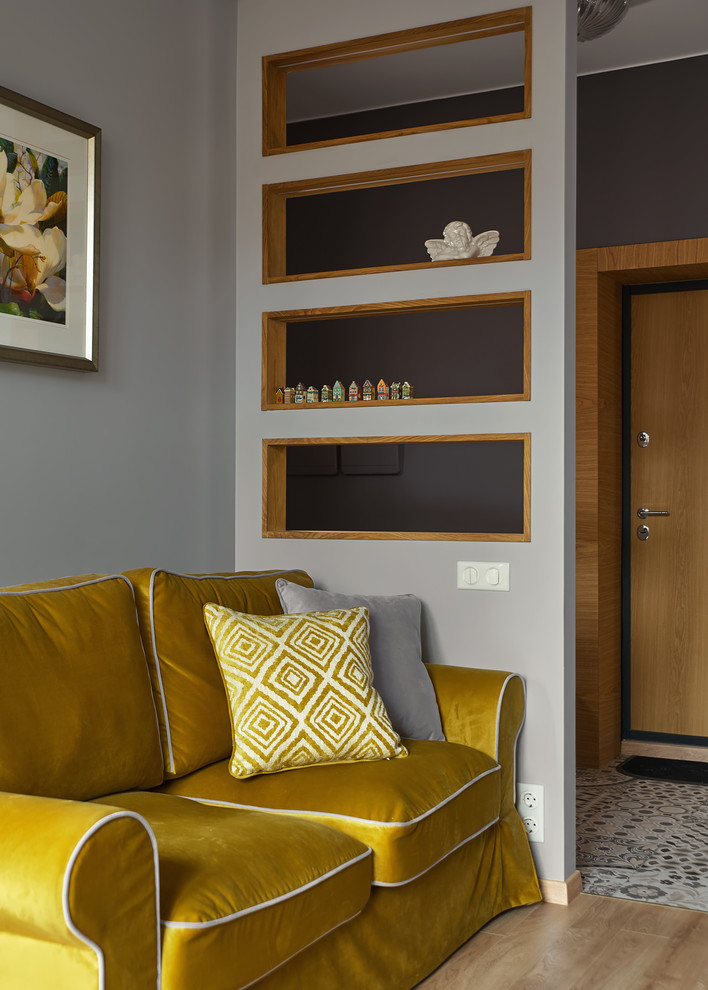 Идея дизайна: маленькая гостиная комната в стиле неоклассика (современная классика) с серыми стенами, светлым паркетным полом, бежевым полом и горчичным диваном для на участке и в саду
