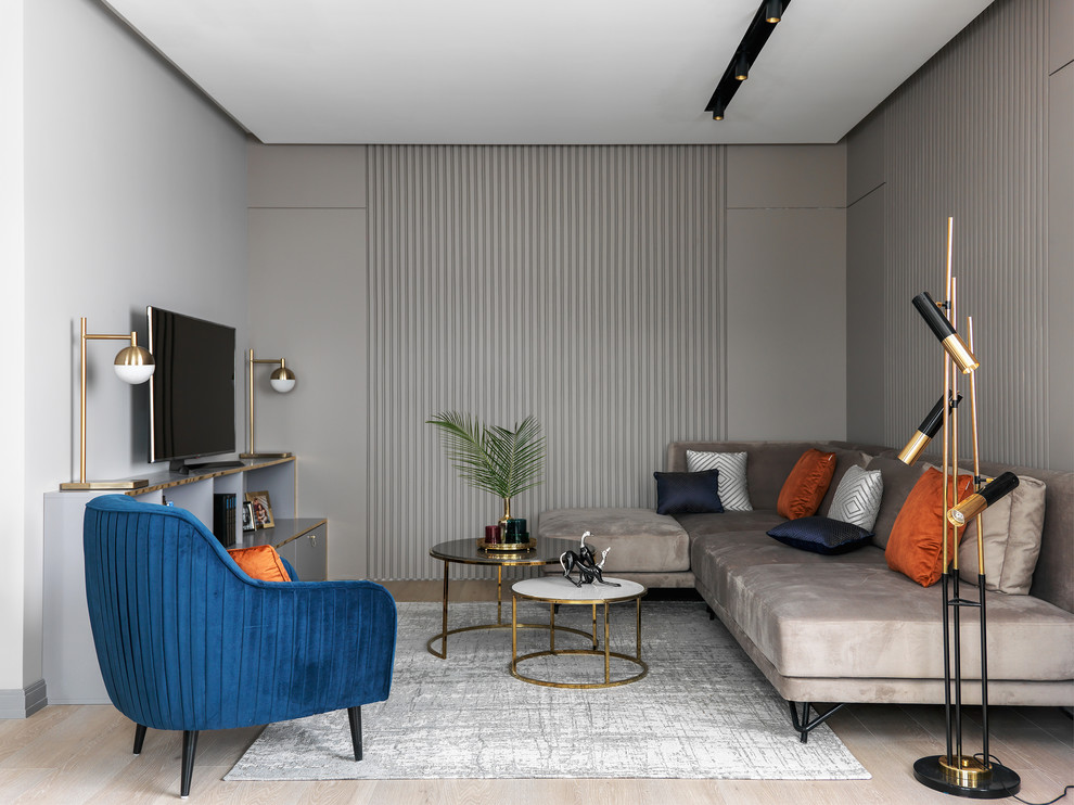 Diseño de salón actual grande con paredes grises, suelo de madera clara, suelo beige y televisor independiente