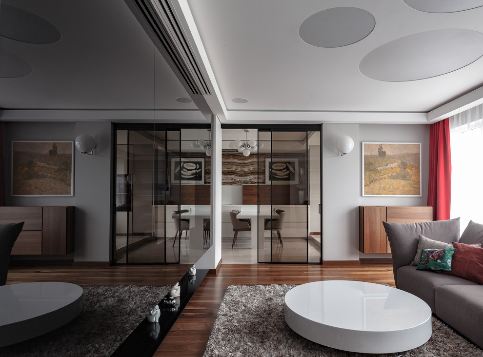 Источник вдохновения для домашнего уюта: изолированная гостиная комната среднего размера в современном стиле с серыми стенами, темным паркетным полом, скрытым телевизором и коричневым полом