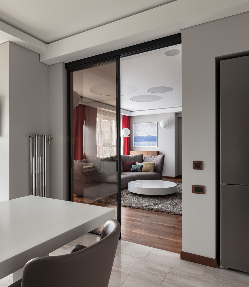 Свежая идея для дизайна: большая изолированная гостиная комната в современном стиле с серыми стенами, темным паркетным полом, скрытым телевизором и коричневым полом - отличное фото интерьера