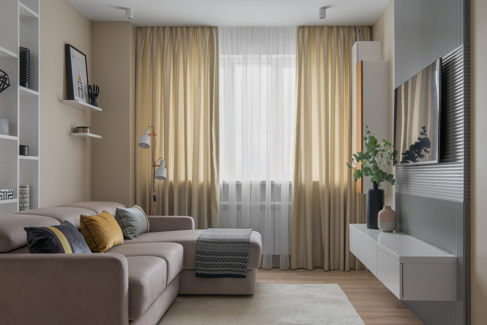 На фото: открытая гостиная комната среднего размера в современном стиле с бежевыми стенами, светлым паркетным полом, телевизором на стене и бежевым полом без камина с