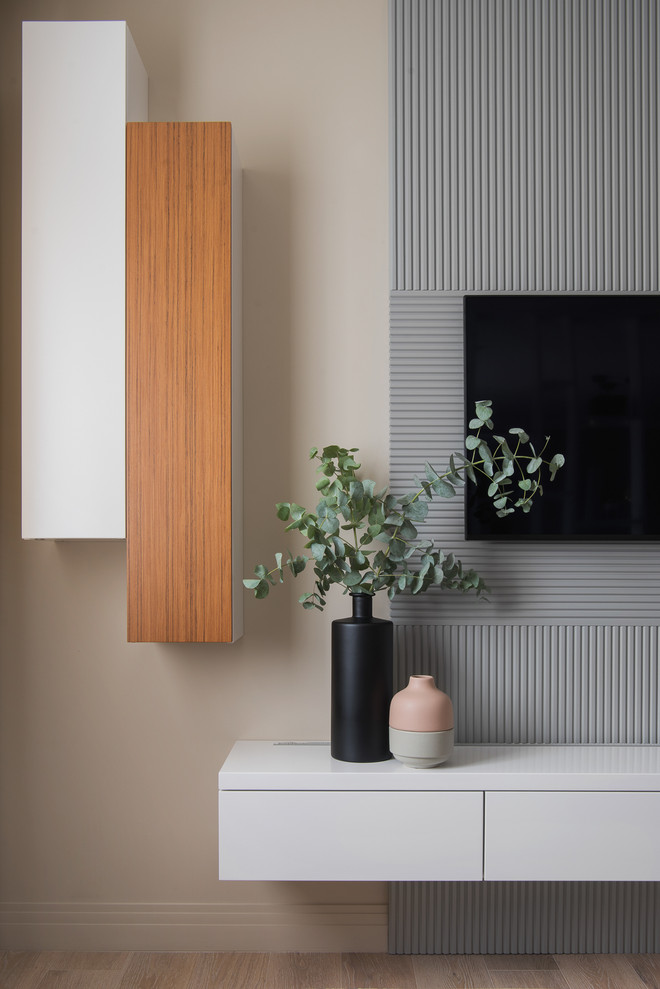 Foto de salón abierto contemporáneo de tamaño medio sin chimenea con paredes beige, suelo de madera clara, televisor colgado en la pared y suelo beige