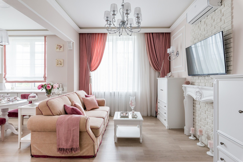 Diseño de salón abierto tradicional pequeño con paredes rosas, televisor colgado en la pared, suelo de madera clara y suelo beige