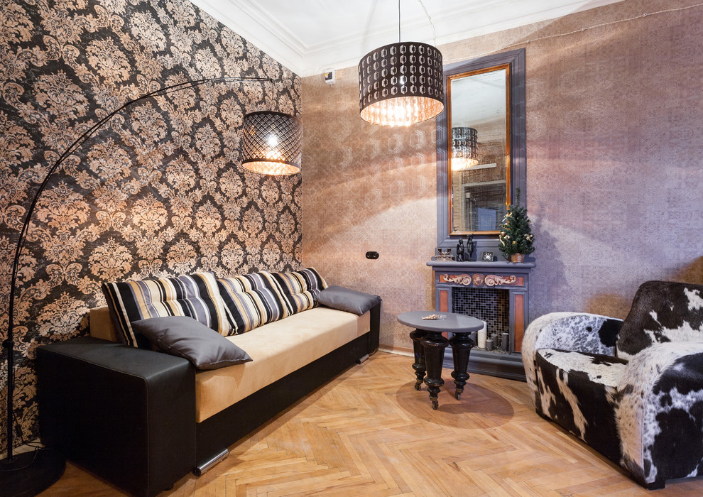 Esempio di un piccolo soggiorno industriale con pareti grigie, parquet chiaro e camino classico