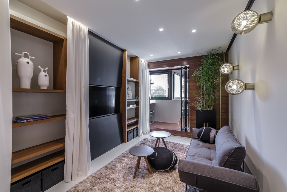 Свежая идея для дизайна: изолированная гостиная комната в современном стиле с белым полом, белыми стенами и телевизором на стене - отличное фото интерьера