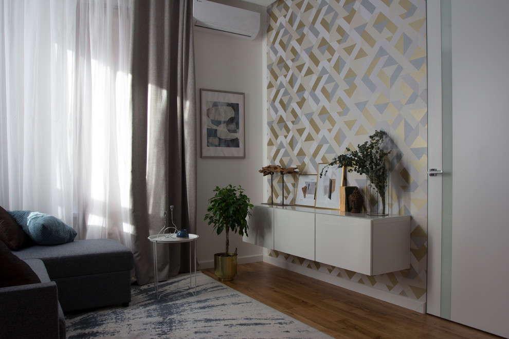 Modelo de salón abierto actual pequeño sin televisor con paredes blancas, suelo de madera en tonos medios y suelo beige