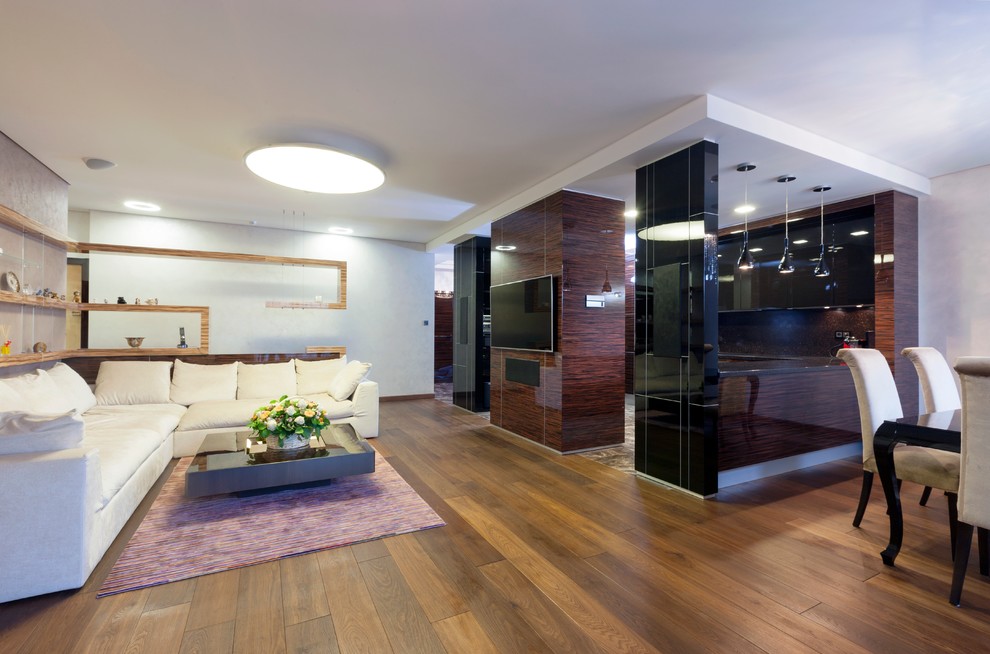 Modernes Wohnzimmer mit braunem Holzboden und TV-Wand in Moskau