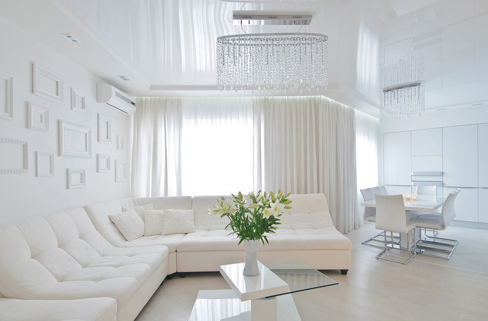 На фото: открытая, объединенная гостиная комната в современном стиле с белыми стенами и светлым паркетным полом с