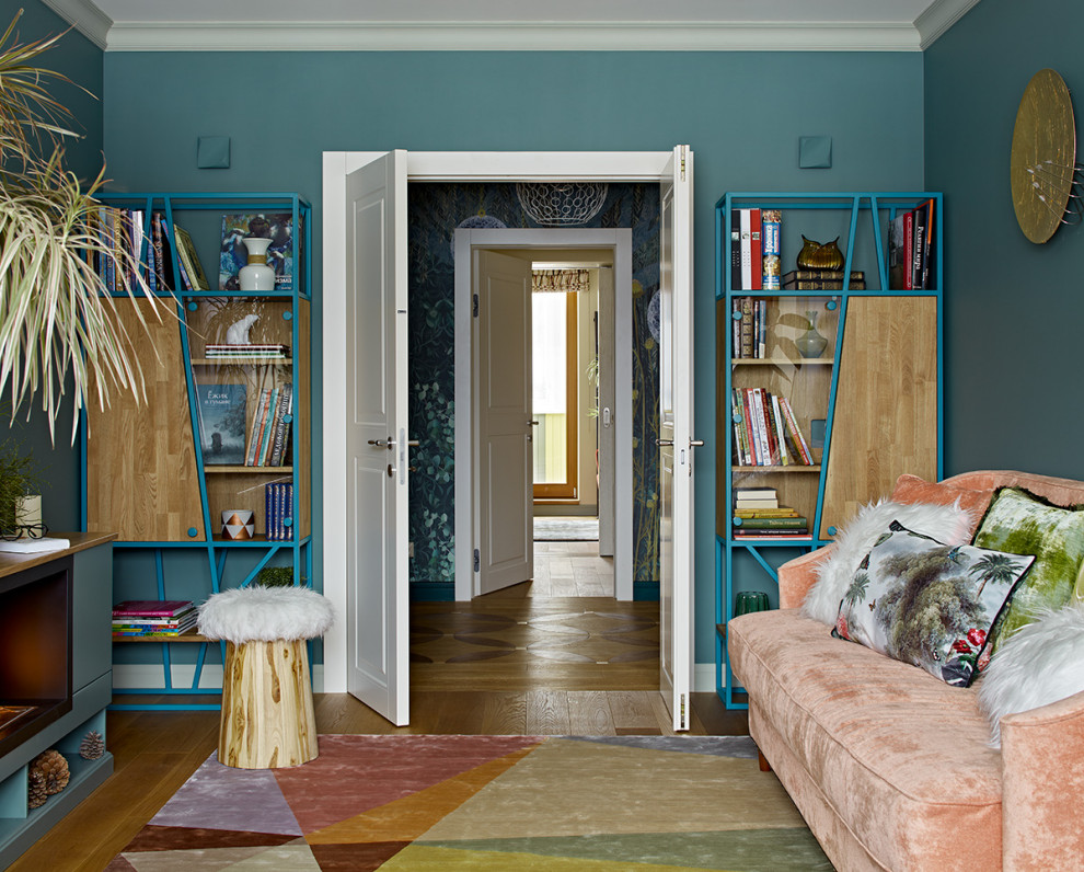 Modern inredning av ett mellanstort avskilt allrum, med ett bibliotek, blå väggar, mellanmörkt trägolv, brunt golv, en bred öppen spis och en spiselkrans i trä