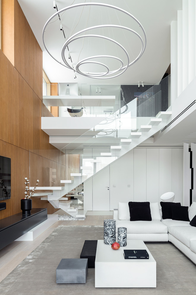 Foto di un soggiorno design con pareti marroni, parquet chiaro, TV a parete e pavimento beige