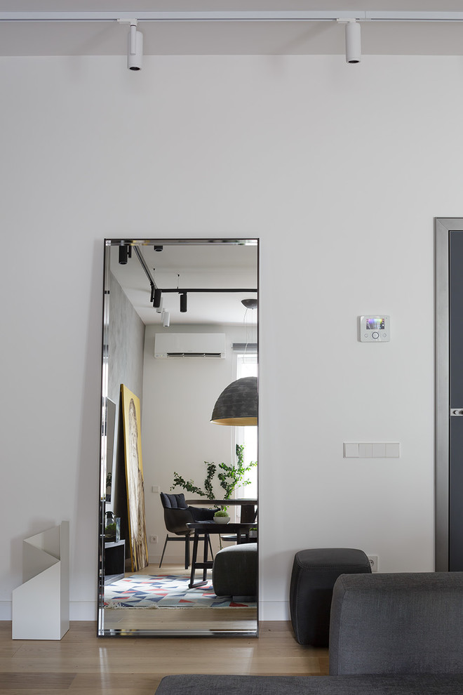 На фото: изолированная гостиная комната среднего размера в современном стиле с серыми стенами, телевизором на стене и бежевым полом
