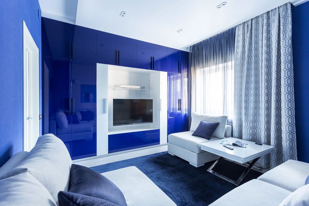 Imagen de sala de estar contemporánea con paredes azules, televisor colgado en la pared y suelo blanco