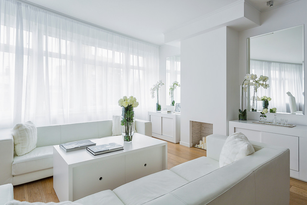 Imagen de salón contemporáneo con paredes blancas y suelo de madera en tonos medios