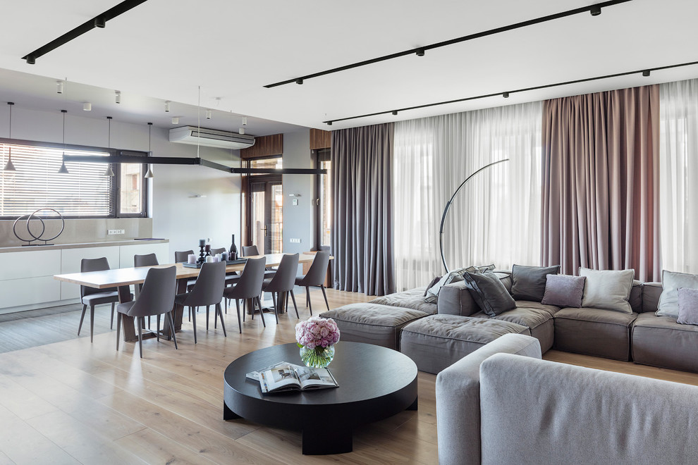Offenes Modernes Wohnzimmer mit grauer Wandfarbe, hellem Holzboden und beigem Boden in Moskau