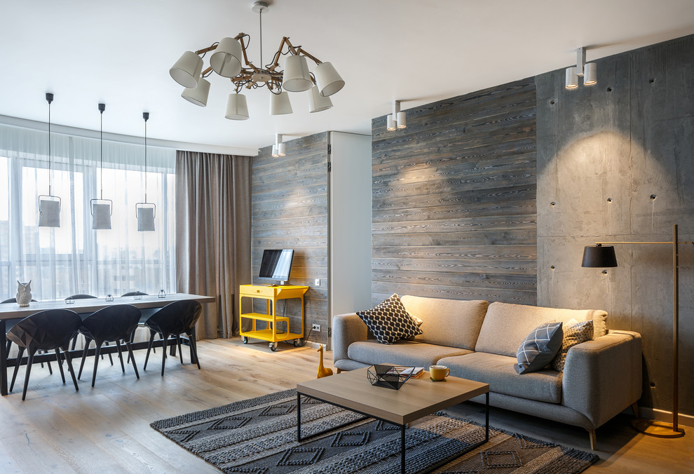 Cette image montre un salon design avec un mur gris et parquet clair.