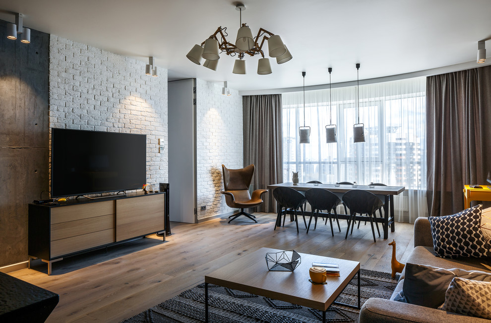 Diseño de salón para visitas abierto actual con paredes blancas, suelo de madera en tonos medios y televisor independiente