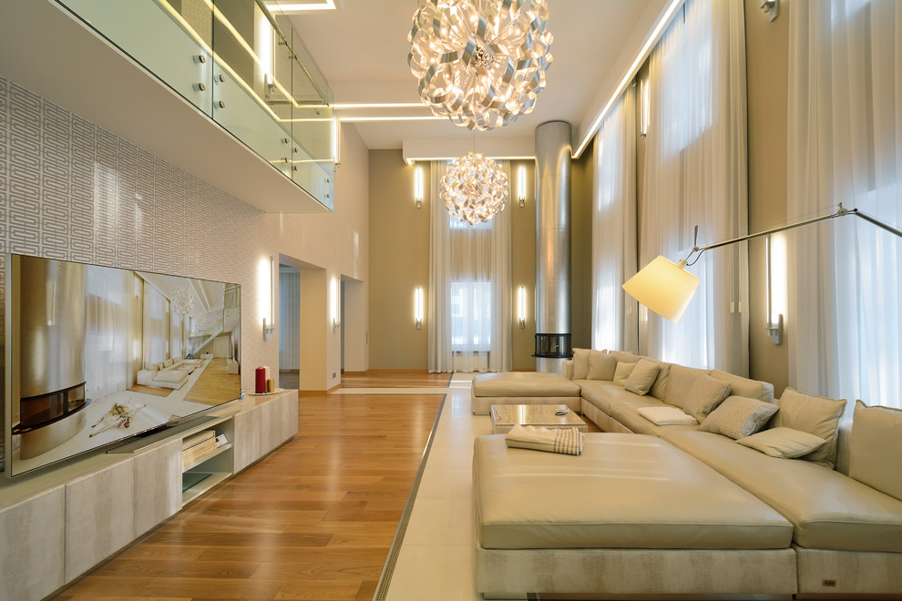 Идея дизайна: огромная открытая гостиная комната в современном стиле с бежевыми стенами, угловым камином и отдельно стоящим телевизором