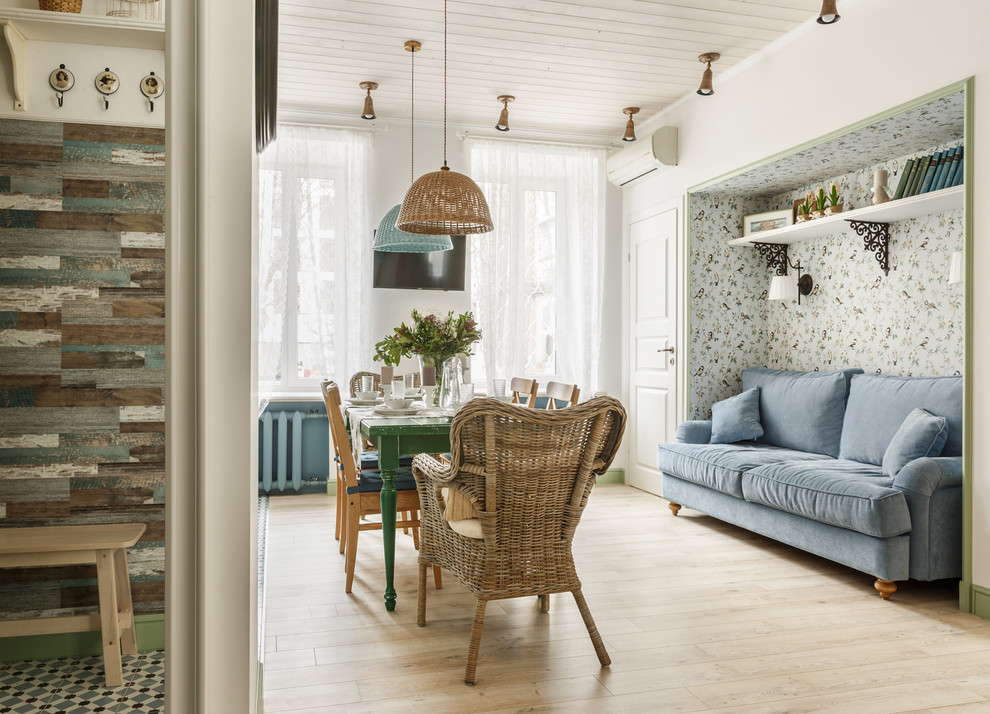 Foto di un soggiorno scandinavo con libreria, pareti bianche, pavimento in laminato e TV a parete