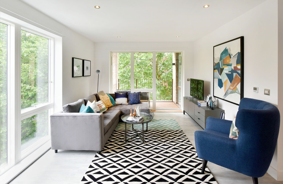Inspiration pour une salle de séjour design avec un mur blanc, un téléviseur indépendant et un sol gris.