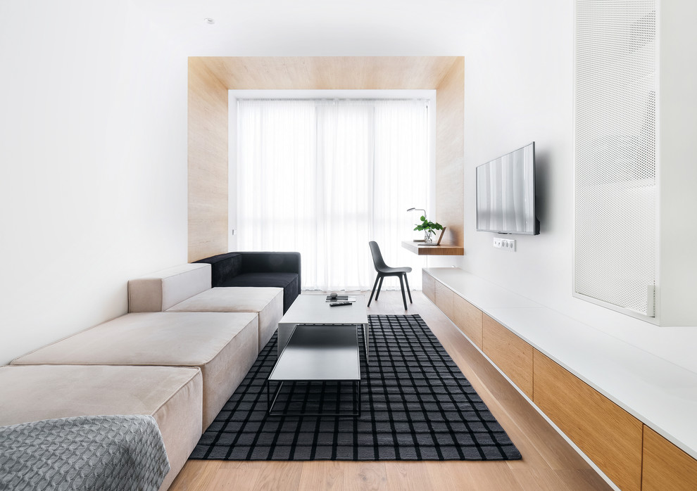Источник вдохновения для домашнего уюта: изолированная гостиная комната в современном стиле с белыми стенами, паркетным полом среднего тона, телевизором на стене и бежевым полом
