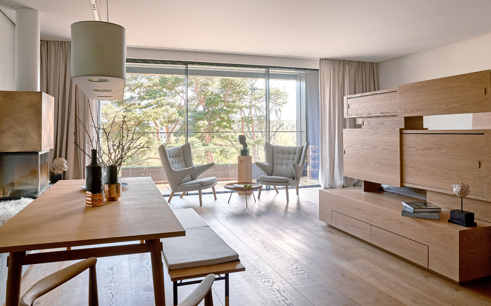 Foto di un soggiorno design di medie dimensioni e aperto con camino classico, pavimento beige, pareti bianche e pavimento in legno massello medio