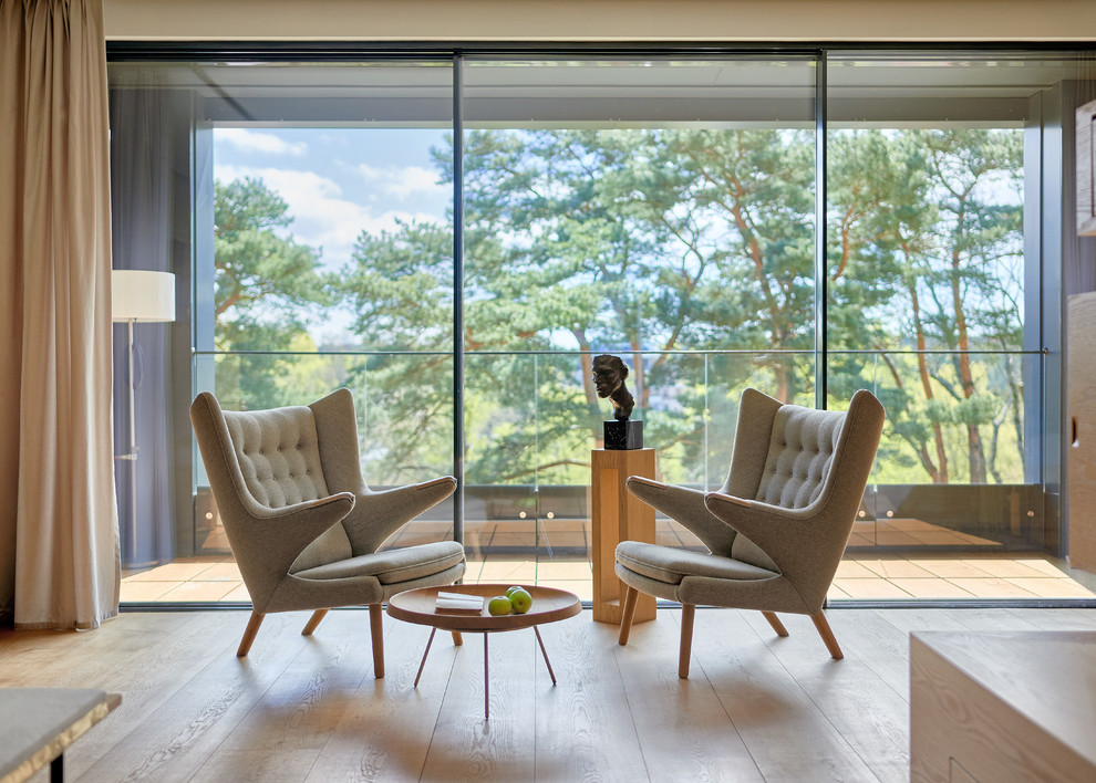 Ispirazione per un soggiorno design di medie dimensioni e aperto con pareti bianche, pavimento in legno massello medio e pavimento marrone